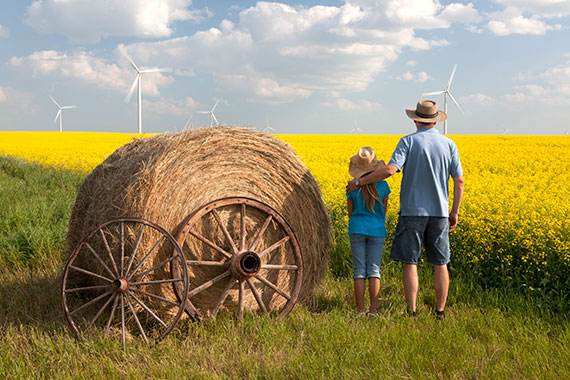 A man pats his daughter on the shoulder in a field in Manitoba, he’s just completed an alcohol addiction rehab program and attained sobriety