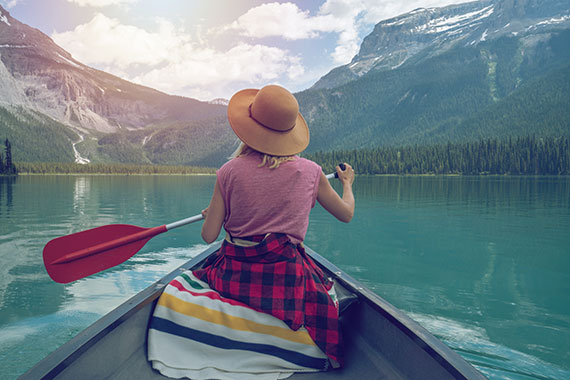 A woman paddles a canoe on a beautiful British Columbia Lake, and thinks that life is good now that she has completed recovery for alcohol addiction